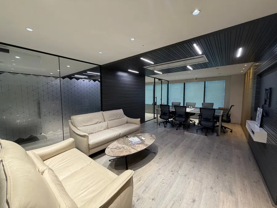 Lounge seating and the glass-walled meeting room inside the Stone Hill office in Manikonda