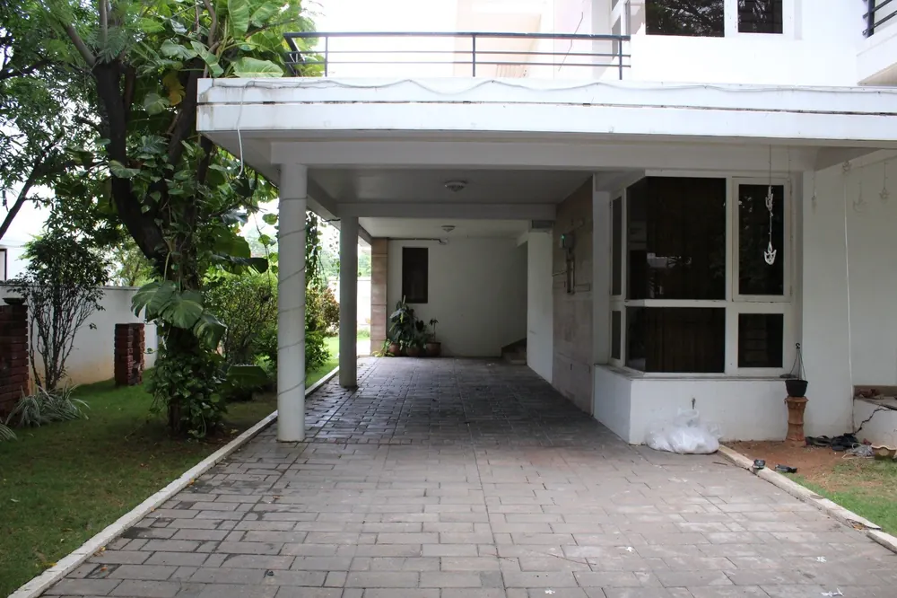 Covered two-car driveway and stone-paved porch at the villa entrance