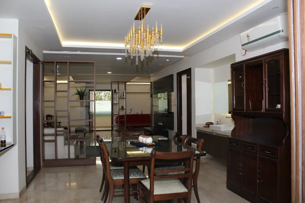Chandelier over the dining space of the Royal One 3BHK, with crockery cabinet and TV unit