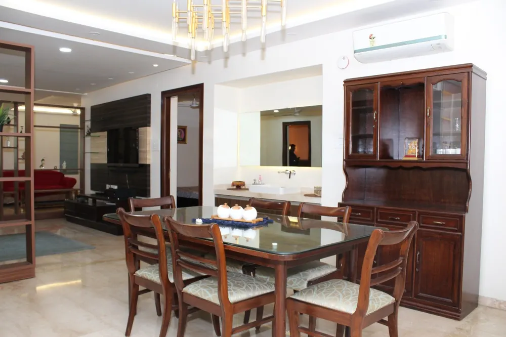 Six-seater dining table of the Royal One 3BHK beside the crockery cabinet and wash counter