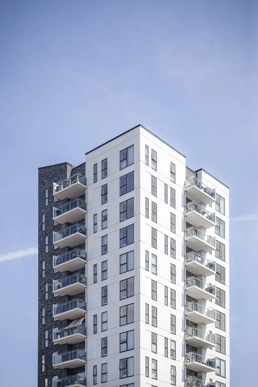 Upper floors of a modern white commercial building against a clear sky